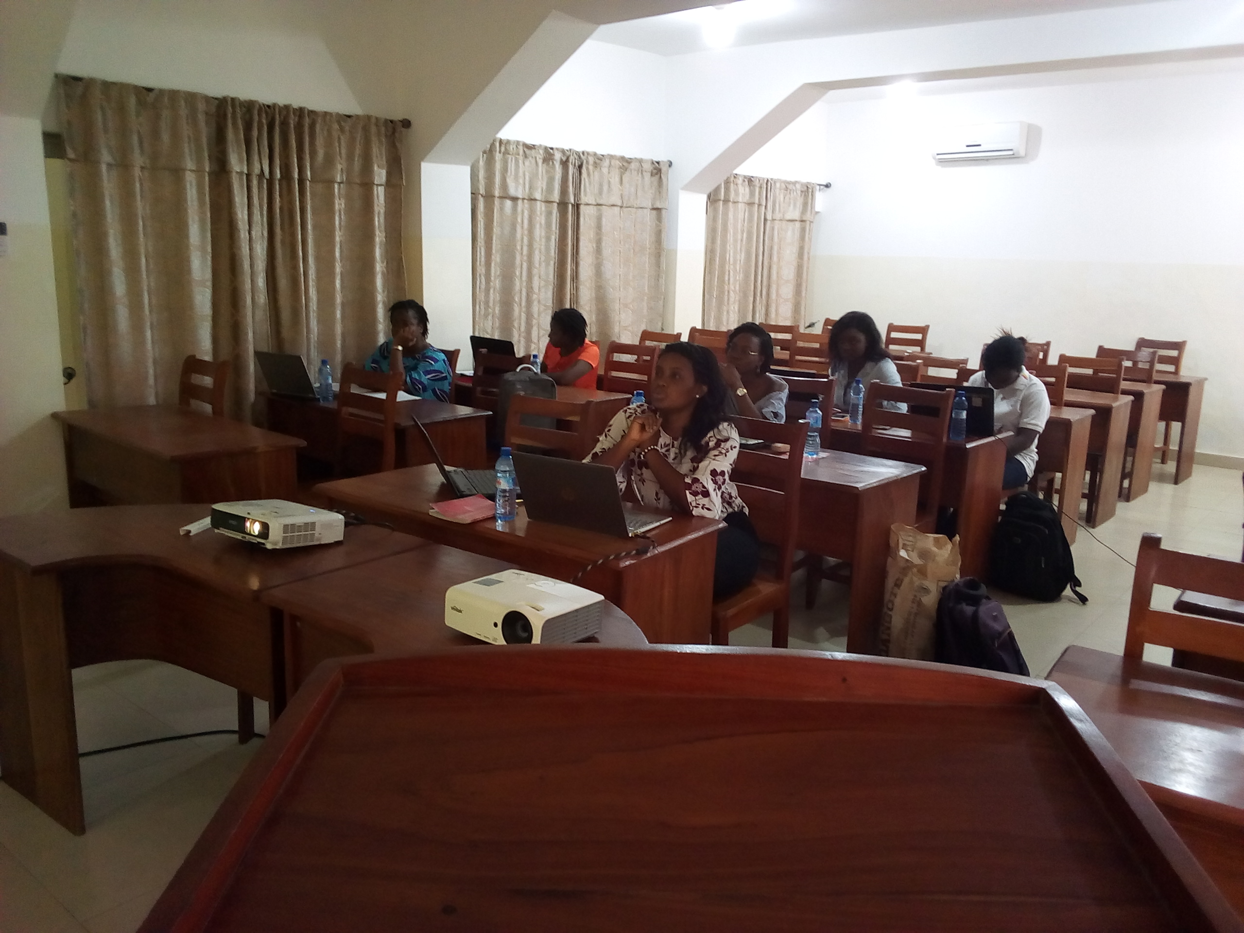 Ruth Ouangbey presenting at the front of a room while members follow along and take notes