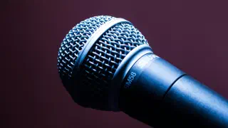 Microphone on a stand in front of an audience