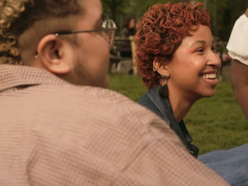 Group of friends of varying genders hanging out in a park