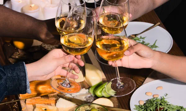 Group of friends of varying genders celebrating at a dinner party