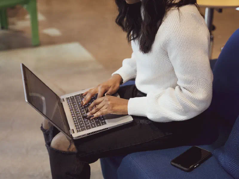 Black woman typing on a laptop in an office setting