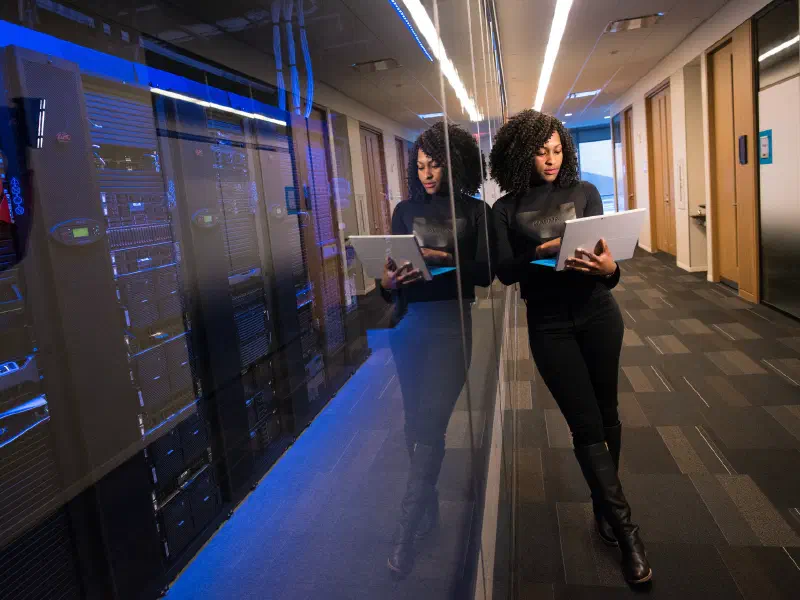 Woman of color focused on work at a laptop in a tech environment