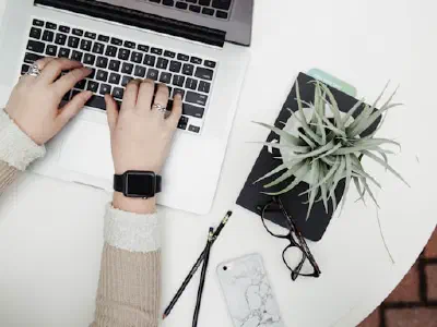 Hands typing on a laptop keyboard