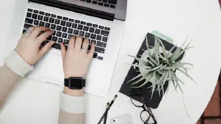 Hands typing on a laptop keyboard