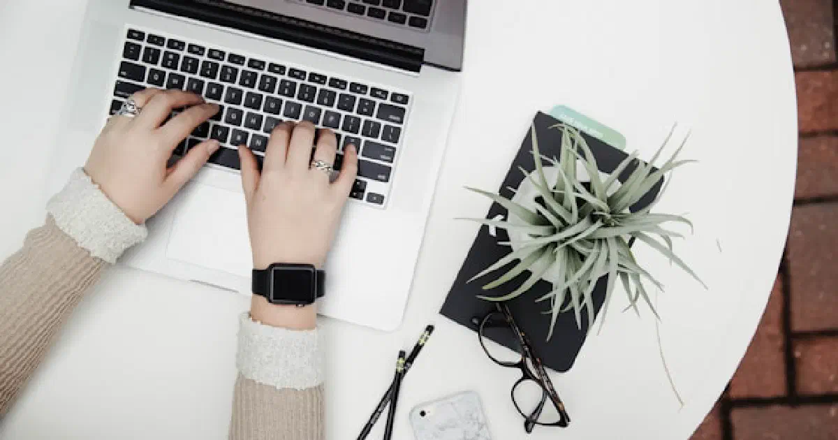 Hands typing on a laptop keyboard